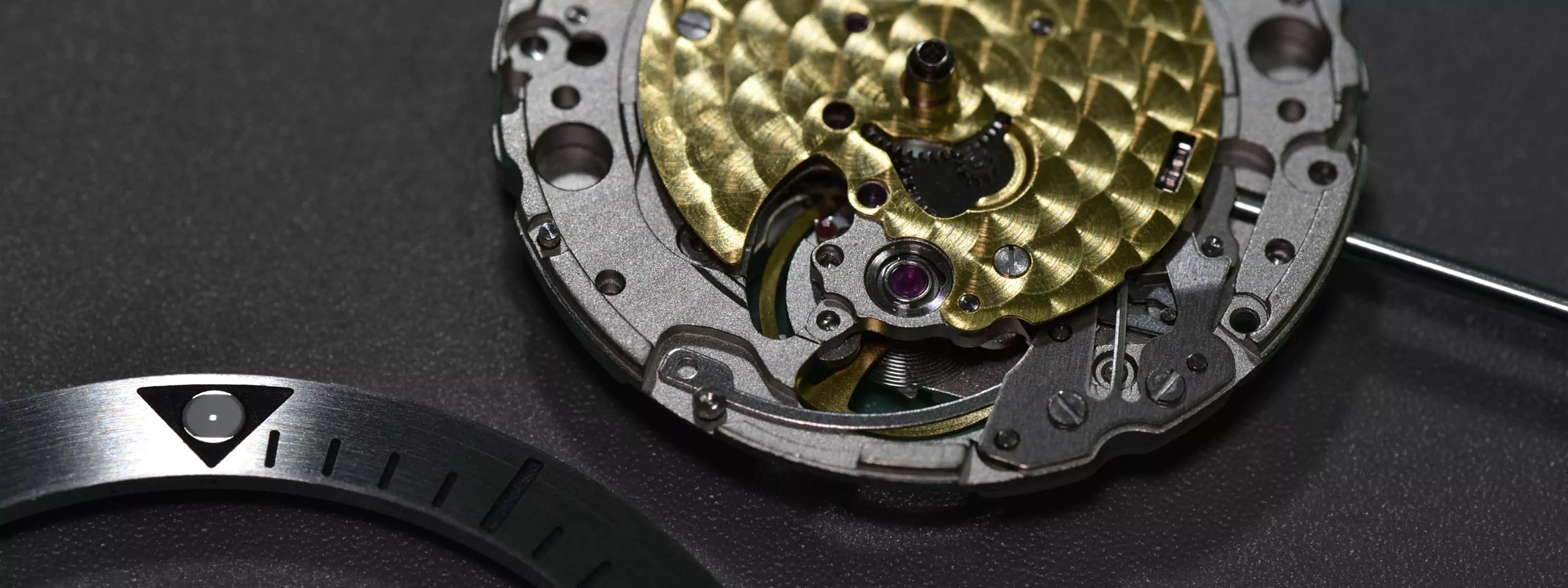 Close-up of a miyota watch mechanism on a dark background