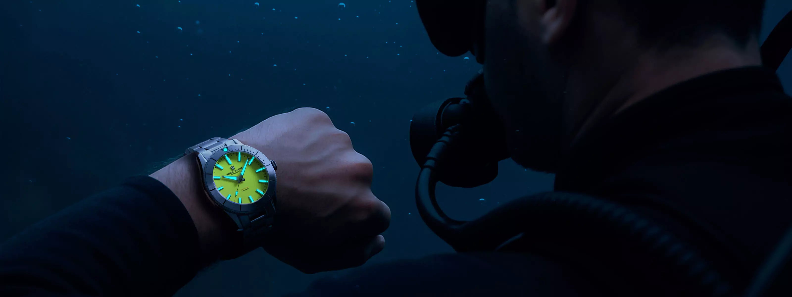 Diver underwater wearing a watch with a full lume dial while diving