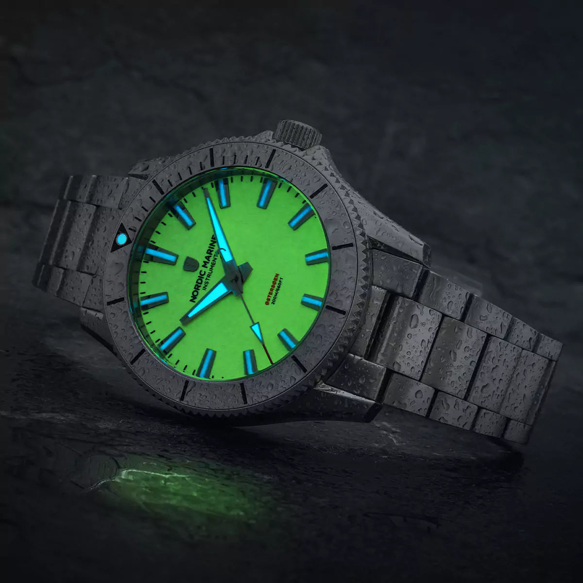 Dive watch with a glowing green full lume dial and wet stainless steel bracelet on a dark background