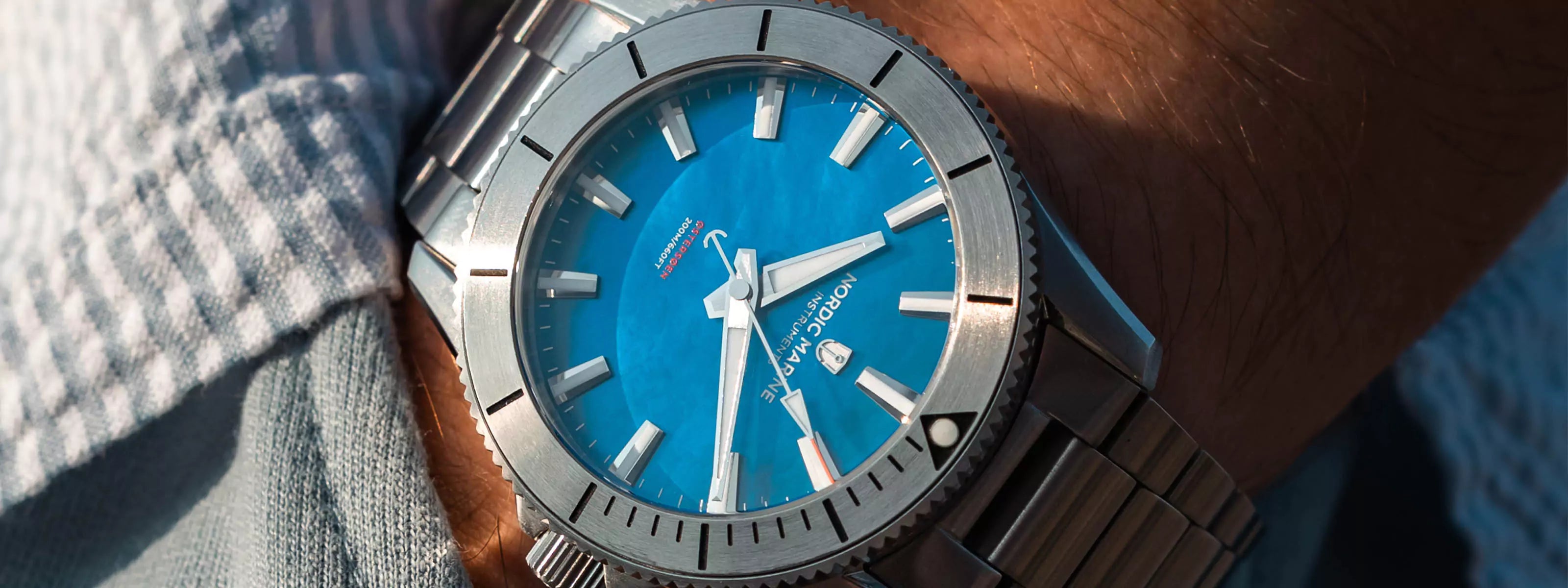 Close-up of a wrist wearing a watch with a blue mother-of-pearl dial and silver case pocket shot